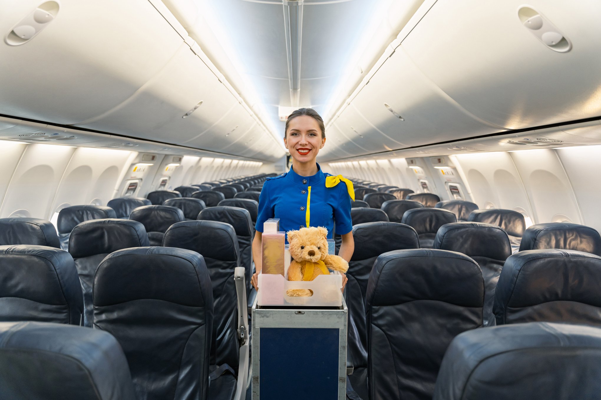 Smiling Air Hostess Leading Trolley Cart with Gifts